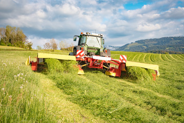 Fototapeta premium Silagewerbung - Landwirt beim Abmähen einer Wiese