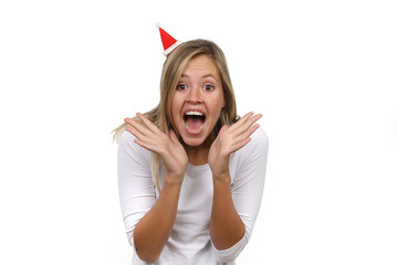 Hübsche blonde Frau mit Weihnachtsmütze begeistert