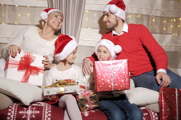 Rodzina na kanapie z prezentami podczas Świąt Bożego Narodzenia - obrazy, fototapety, plakaty