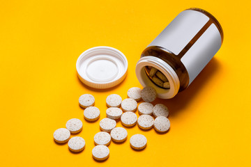 Medical tablet on yellow background