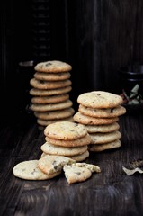 Stacks of cookies on a wooden table. Dark background
