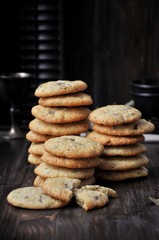Stacks of cookies on a wooden table. Dark background