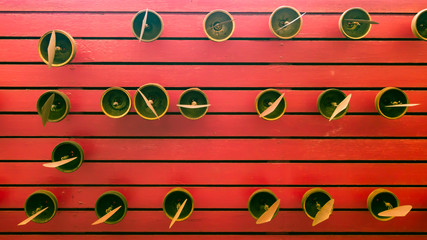 Abstract red wooden stripes texture with brass small bells pattern.