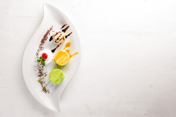 Panakota with taste of pistachio, orange, chocolate. On a wooden background. Free space for your text. Top view.