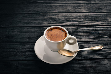 A cup of espresso coffee on a dark wooden background. Top view. Free space for text.