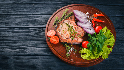 Grilled Steak, with Vegetables. Pork, veal, meat. On a wooden background. Top view. Free space for text.