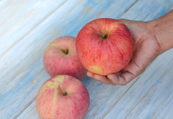 Hand on a big apple with blue background