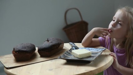 Little child eating butter with her finger. Adorable girl with long blond hair stealing butter from plate - Powered by Adobe