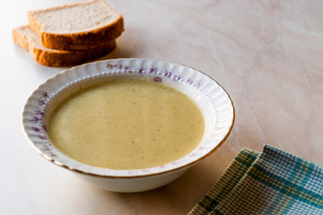 Broccoli Soup with Bread on Ceramic Surface.