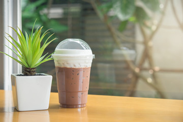 Iced chocolate topped with coco flavor and whipped cream served on desert coffee shop cafe' wooden...