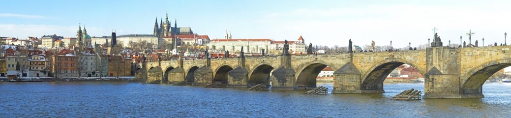 Fototapeta na wymiar A panoramic view of the Prague Castle, Vltava river and the Charles Bridge. Unidentified tourists admiring the famous city
