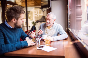 Obraz na płótnie Canvas Senior father and his young son in a cafe.