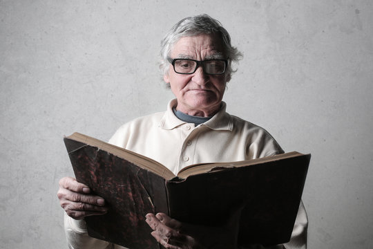 Elderly man readng an old book