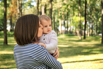 Mother with adorable little daughter together in park