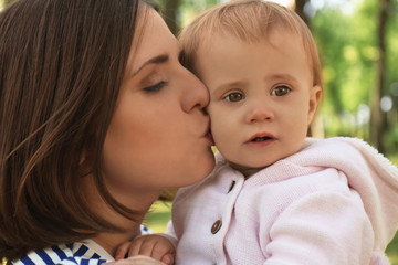 Mother with adorable little daughter together in park