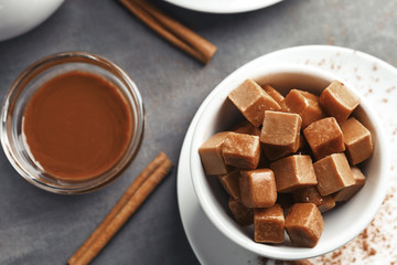 Bowl with sweet caramel candies on table