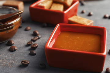 Gravy boat with sweet caramel sauce on table