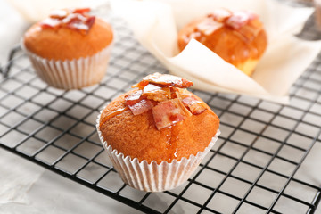 Cooling rack with tasty bacon muffins on table