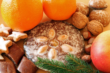 gingerbread, oranges and nuts on wood