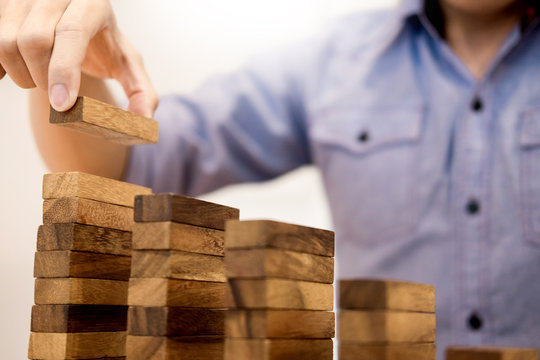 Business man hand put wooden blocks arranging stacking for development as step stair, Concept of growth and success plan