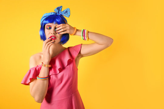 Young Woman With Rainbow Makeup And Blue Hair On Yellow Background