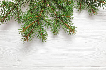 Mockup Christmas tree branches border over white wooden background, with space for your text