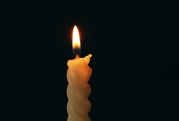 Spiral candle burning in darkness, closeup