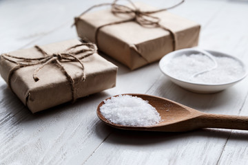 sea salt on wooden background with gift boxes