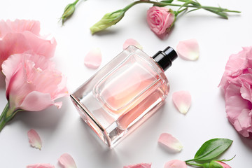 Obraz na płótnie Canvas Bottle of perfume with flowers on white background