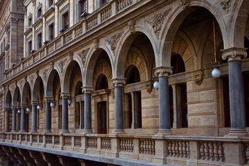 Fototapeta na wymiar Stone arches of National Theatre in Prague / Detail of a historical building wall with columns and windows