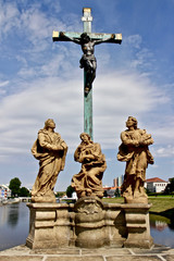 Statue of a crucified Jesus / Sculptures on a stone bridge of czech town Pisek