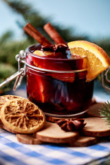 Mulled wine in a glass. Christmas hot mulled wine in a glass with spices and citrus fruit. Mulled wine with cinnamon, anise and orange. Christmas atmosphere
