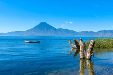 Wooden pier at Lake Atitlan on the shore at Panajachel, Guatemala. With beautiful landscape scenery of volcanoes Toliman, Atitlan and San Pedro in the background.