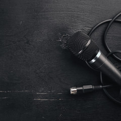 Microphone on a wooden black table. Studio. Top view. Free space for text. Copy space.