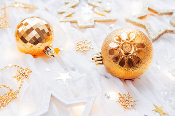 Fototapeta na wymiar Christmas and New Year holiday background with decorations and light bulbs. Golden shining balls, snowflakes and star confetti.