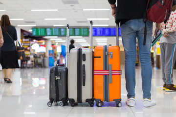 Young tourist standing with his luggages in the airport while traveling on vacations