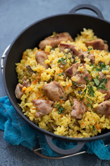 Cast-iron pan with pilaf, selective focus, vertical shot