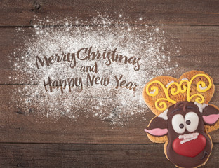 Christmas cookies of different shapes and sizes with a festive decor on a wood background. Holiday...