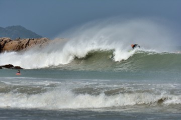 Surfeur sur une vague, plage Trestraou de Perros-Guirec en Bretagne