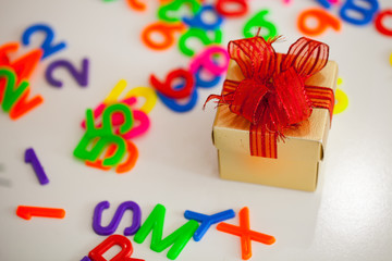 Small gift box and colorful abc alphabet block plastic letters, copy space for added text. Merry Christmas concept