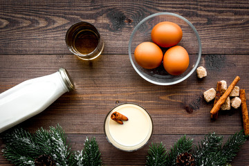 Ingredients for eggnog. Eggs, milk, cinnamon, whiskey on dark wooden background top view