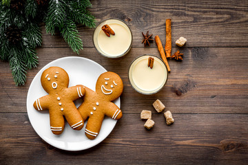 Eggnog for christmas evening. Two glasses near gignerbread cookie and spruce branch on dark wooden background top view copyspace