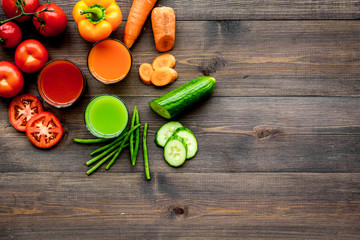 Fresh detox beverages with vegetables on dark wooden background top view copyspace