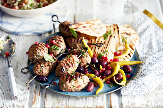 Lamb kofta and flat bread on plate, close-up
