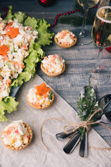 Crab salad tarts on wooden background. Christmas holiday buffet table served by snacks.  Line of canape