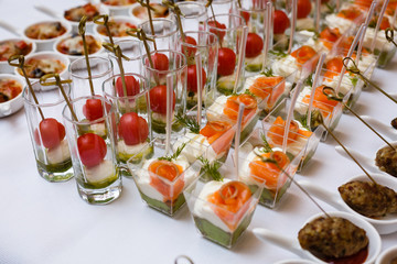Little glasses with fresh salads stand on white table