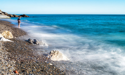 Blurred water on the sea rocks, long exposure on Italian Coast