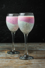 cocktail in a high-necked glass with berries, chia seeds, etc.