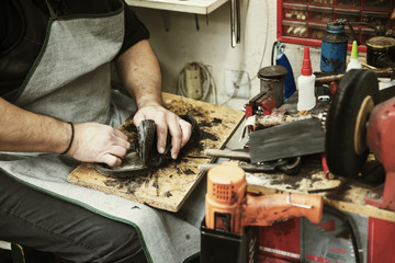 Shoemaker repairing a shoe sole in workshop
