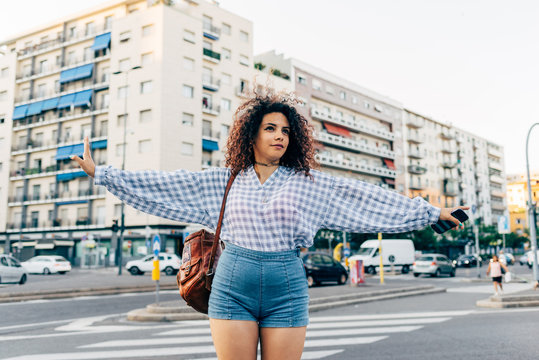 Woman in street, residential block in background, Milan, Italy